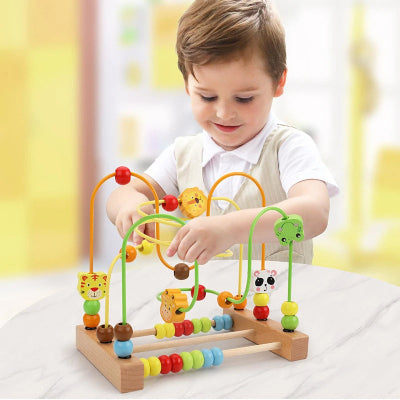 Tout petit en plein activité motrice, poussant les petites perles du cube motricité bébé des doigts des deux mains