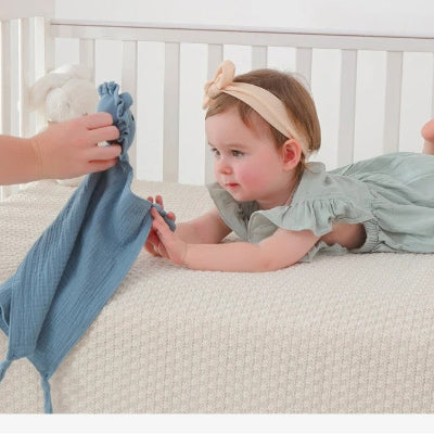 bébé établit un contact visuel et tactique avec son doudou lion