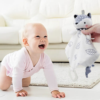 un bébé au souris trop mignon rampant vers son doudou renard