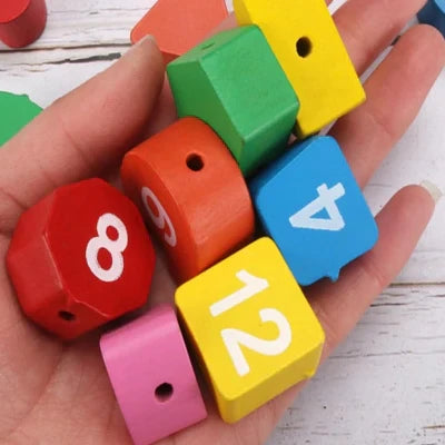 Les petits trous de ficelles du jouet bebe bois pour la concentration et  la pré cision