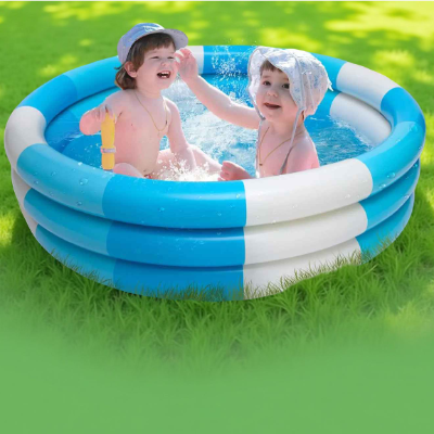 Deux bébé jouent  à taper sur l'eau dans la piscine bebe en plein soleil .