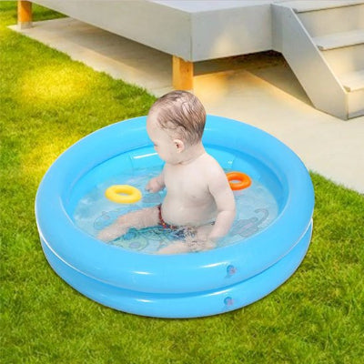 Bébé joue avec ses jouets en profitant du soleil dans sa piscine gonflable.