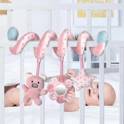Bébé s'exerce à saisir les éléments supendus de sa spirale d'activité enroulé sur son berceau.