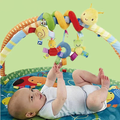 Bébé en plein effort de motricité pour essayer d'attraper les hochets suspendus de sa Spirae d'activité.