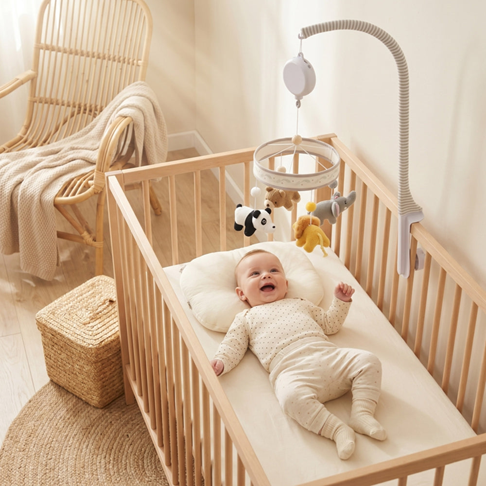 Bébé joue tout seul avec le mobile bebe qui tourne au dessus de lui