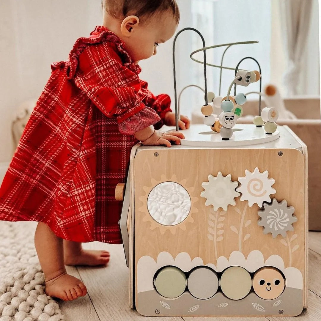 Bébé essaye de retourner la partie supérieure de son cube de motricité 