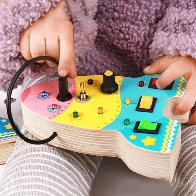 Les petites mains manipulent le Tableau Montessori BusyBoardCircuit™ fusée 