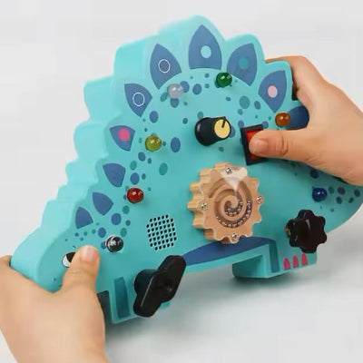 Manipulation des commandes circuit et lumineux du Tableau Montessori Stégosaure des deux petites mains 
à la fois