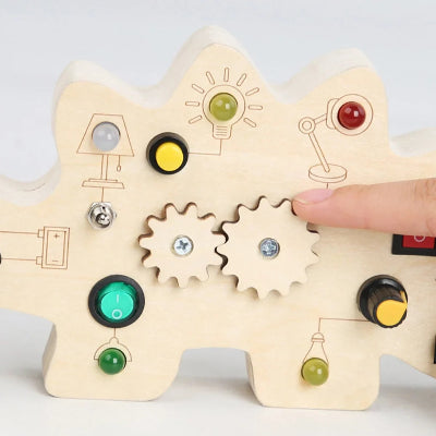 Manipulation des engrenades du tableau Montessori Dinosaure avec petits doights.