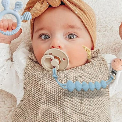 Agripper à l'anneau de dentition et l'attache sur la tétine pour ne pas se perdre