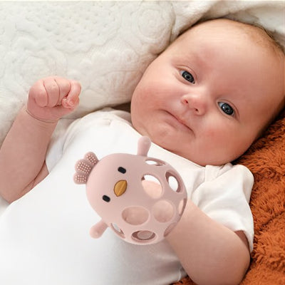 Anneau de dentition en forme de poussin porter à la main de bébé comme chaussette.