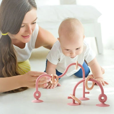 Anneau de dentition avec ventouses fixé au sol pour stimuler la reptation