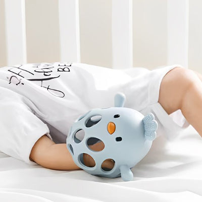 Anneau de dentition en forme de poussin positionné pour ne pas porter les doigts à la bouche. 