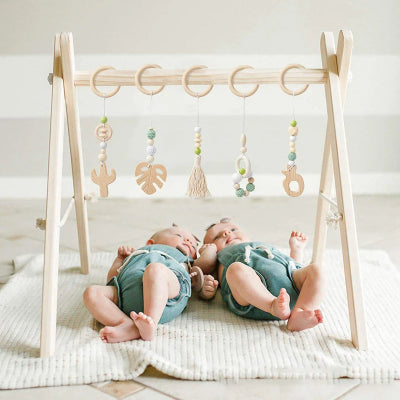 Les jumeaux se partage la même arche eveil bebe avec plus de pendentifs