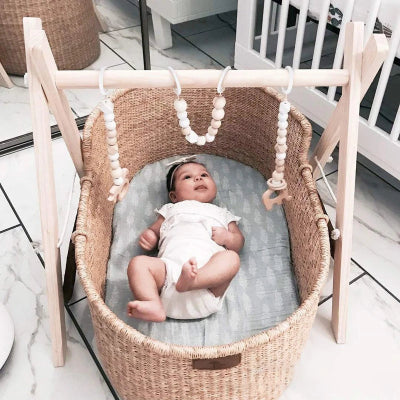 Un bébé, membres contracté, essai de communiquer avec les pendentifs de l'arche eveil bebe. 