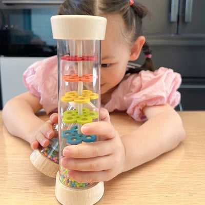 Votre enfant reste captivé par les couleurs et textures de son bâton de pluie.