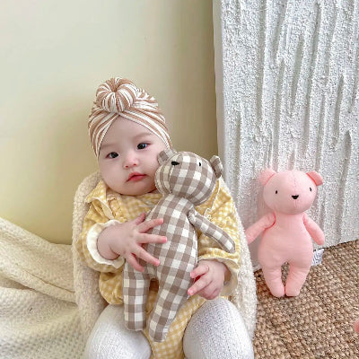 Bébé serre son doudou ourson dans ses bras