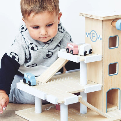 Bébé inspecte la circulation des véhicules sur le jouet bebe bois