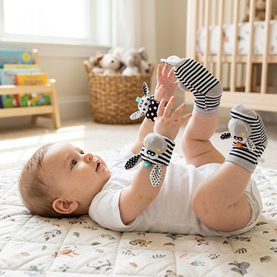 bébé joint ses pieds et mains qui portent Hochet bébé 