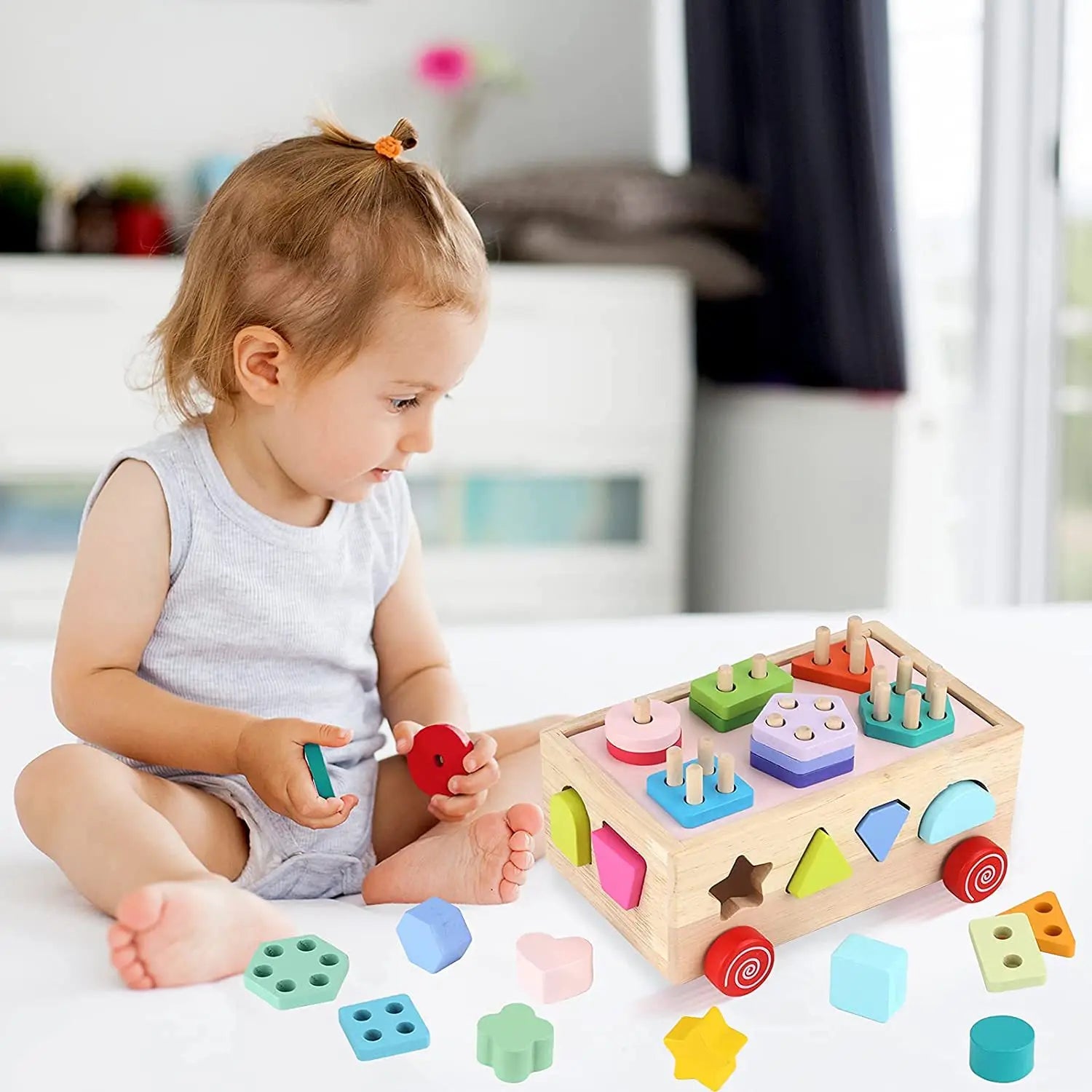 Bebe joue seul sur son cube de motricité sans s'ennuyer 