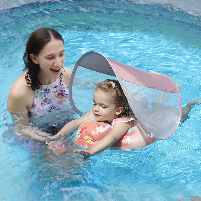 Motricité aquatique intense dans la bouee piscine bebe sous le regard satisfait de maman