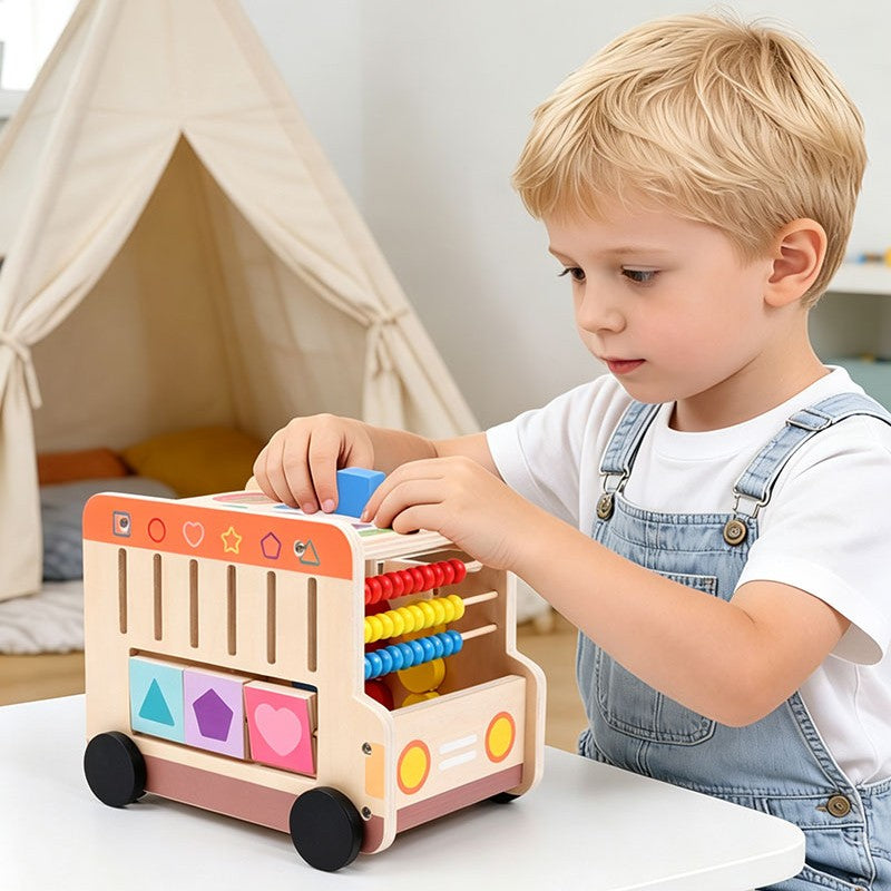 Le tout petit essai de glisser les formes du cube d'activité bébé dans leurs espaces