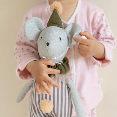 Sérré contre elle, doigts agrippés sur l'oreil, doudou souris represente un pilier emotionnel.