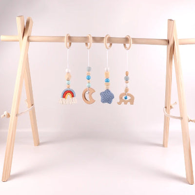 Jouet pour arche d'éveil bleu sur un arche bebe dans un décor boisé