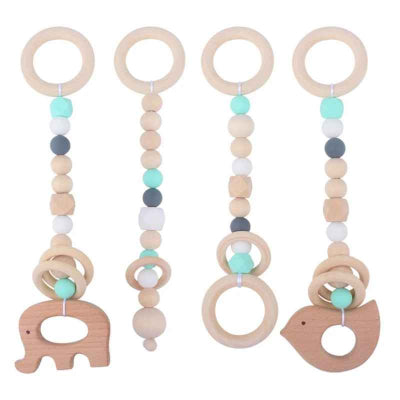 Jouet pour arche d'éveil bébé en bois de hêtre avec des motifs de couleur vert, blanc.