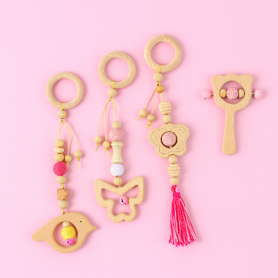 Jouets pour arche d'éveil en bois de hêtre colorés rose, boisé avec une touche de jaune et de blanc  