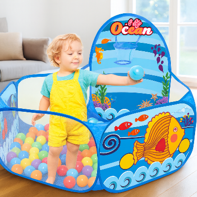Bébé essaie de jouer avec les poissons de sa piscine a balles