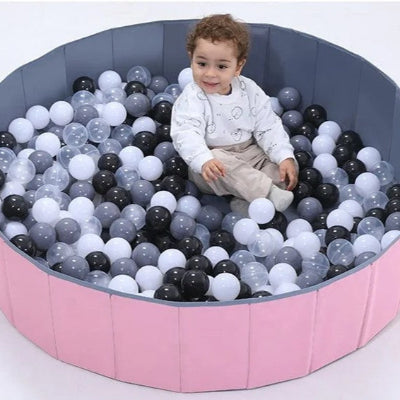 Bébé profite de sa piscine a balle pour bebe et ses balles noir,blanc et transparentes