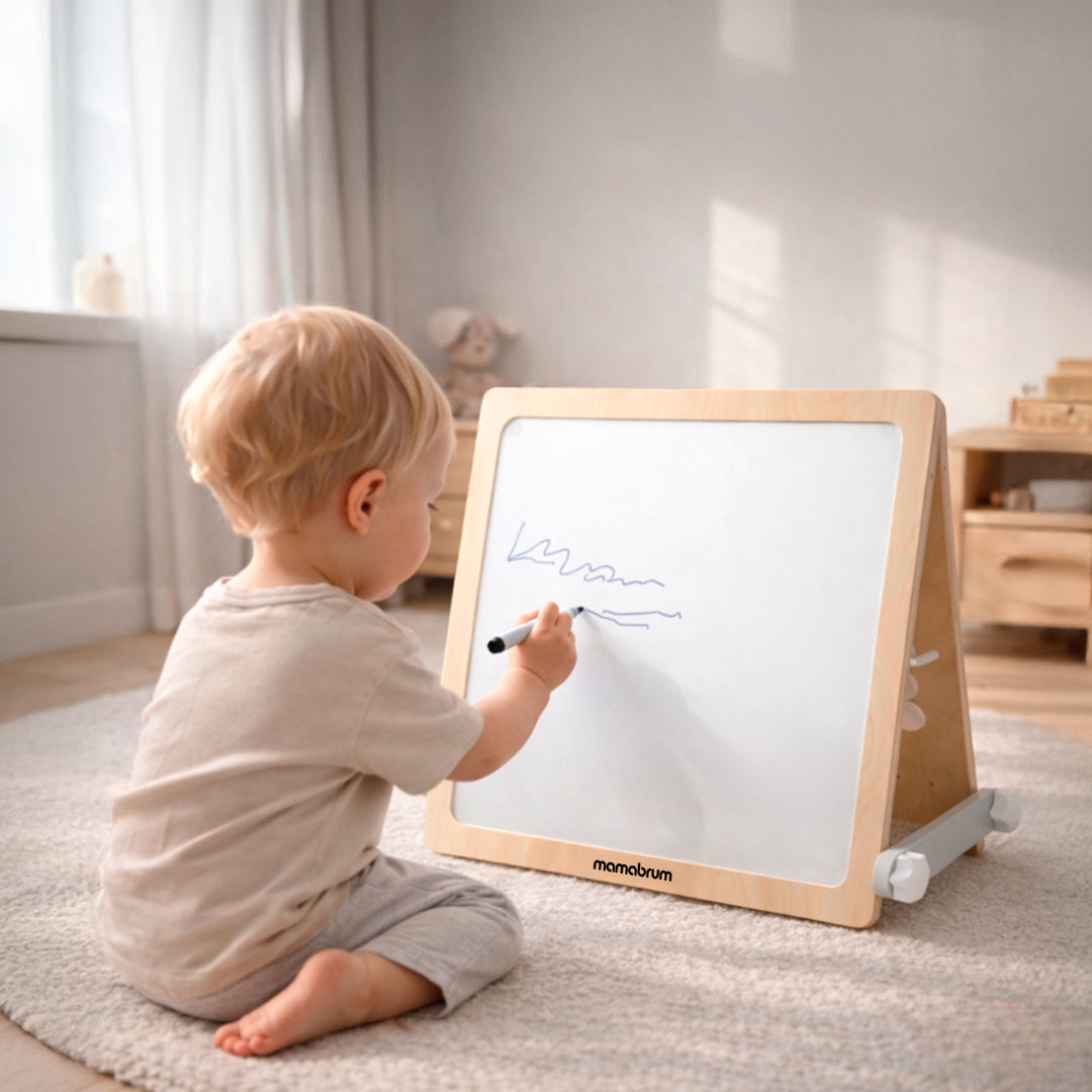 Bébé essaye de faire des traits sur le tableau du cube de motricité bébé 