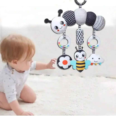 Le tout petit essaie de saisir les hochets suspendus de la Spirale d'activité bébé