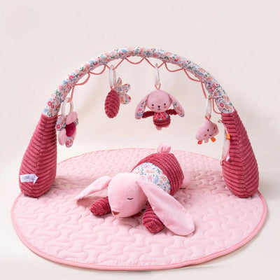 Tapis d’éveil bébé rose avec arche et quatre jouets pour éveil en douceur