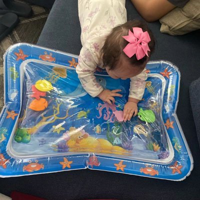 Bébé essaie de saisir les images dans le tapis d'eau