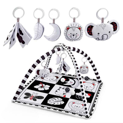 Tapis d'éveil bebe de couleur noir et blanc avec un ensembles de hochets et livre en tissu suspendu a l'arche
