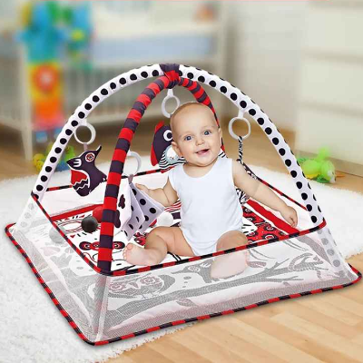 Le Bou de Chou en position assise, s'agrippe au livre en tissu noir blanc de son tapis d'éveil bébé rouge noir