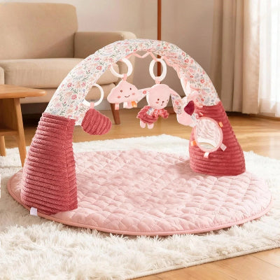 Tapis d’éveil bébé rose avec arche sur moquette de salon pour plus de confort et moments en famille